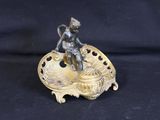 an antique bronze figurine of a boy on a shell