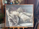 a painting of a woman laying on a bed on a easel