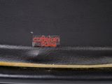 a close up of a black purse with a red logo on it