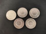 four silver coins sitting on top of each other on a table