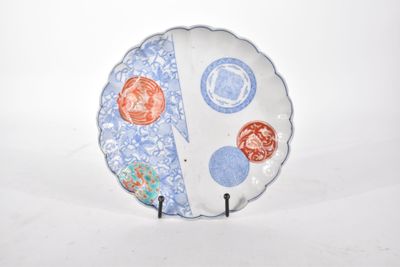 une assiette blanche ornée d'un motif bleu et rouge