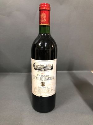 une bouteille de vin rouge posée sur une table à côté d'un verre de vin