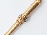 a gold pen that is laying on a white surface