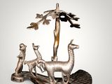 an image of a statue of a man and two llamas with a tree