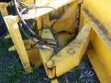 a yellow bulldozer that is sitting in the grass