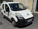 une petite camionnette blanche garée sur le bord de la rue