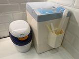 a toothbrush holder next to a toothbrush dispenser in a bathroom
