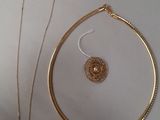 two pieces of jewelry are laying on a white surface
