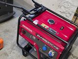 a small red generator sitting on the floor next to a printer