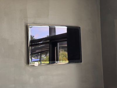 une photo d'un téléviseur accroché au mur dans une pièce