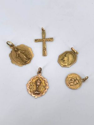 a group of gold religious charms including a cross, a medal, and a medal