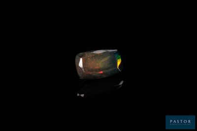 une image représentant une bague sur fond noir, avec un point rouge dessus