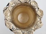 a silver candle holder that has a leaf design on it