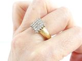 a woman ' s hand holding a gold and diamond ring