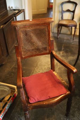 une chaise en bois avec un coussin rouge dans une pièce