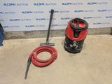 an image of a red vacuum and a red hose on the floor