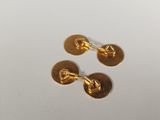 two pairs of gold plated cufflinks on a white surface