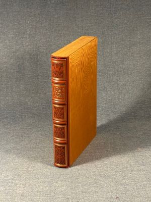 an old book sitting on top of a table next to a gray surface