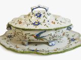 une assiette blanche ornée d'un motif représentant un oiseau bleu et vert