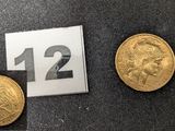 Trois types différents de pièces d'or sont exposés sur un fond noir