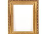 a gold picture frame on a white wall with a white background