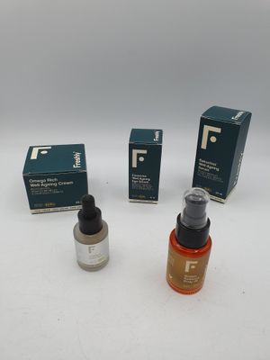 trois bouteilles de liquide et une boîte de savon posées sur une surface blanche