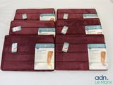 Six paires de semelles sont posées sur un lit recouvert d'un drap blanc.