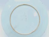 a blue plate with a gold rim sitting on a white surface