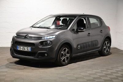 La Citroën grise est garée sur un sol à damier dans un garage