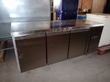 three stainless steel refrigerators sitting in a kitchen