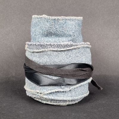 three pieces of fabric wrapped around each other on a black surface