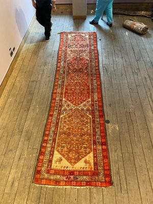 two people that are standing in a room with a rug on the floor