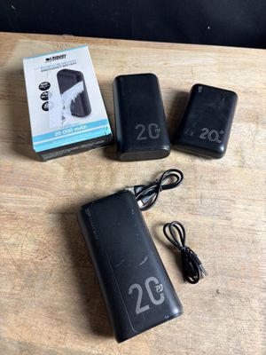 two batteries and a charger sitting on a table next to a box of batteries