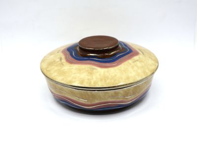 a small bowl with a lid on a white surface