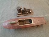 une petite maquette de bateau posée par terre à côté d'une autre petite maquette de bateau