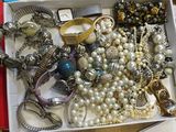 a white box filled with assorted jewelry on a table