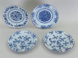 quatre assiettes bleues et blanches ornées de motifs floraux