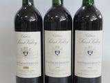 three bottles of wine sitting on top of a white table