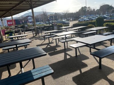 de nombreuses tables et bancs dans un parking