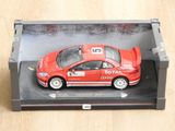 une petite voiture rouge dans une boîte noire posée sur une table