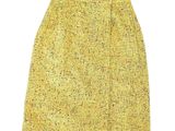 La jupe est jaune et présente un petit motif.