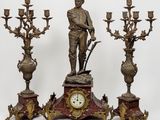 a statue of a man standing next to three candelabs