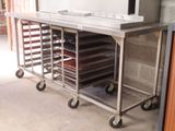 un chariot métallique sur lequel sont disposés de nombreux plateaux de nourriture