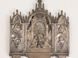 a metal sculpture of a religious scene on a wall