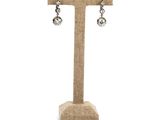 a close up of a pair of earrings on a stand