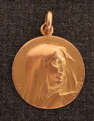 Gros plan sur une médaille d'or portant le visage d'une femme