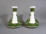 une paire de vases verts et blancs posés sur une table
