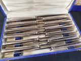 a lot of silverware in a blue case on a table