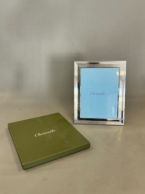 une photo représentant un cadre et un livre posés sur une table