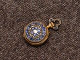 une petite montre de poche en or ornée de pierres bleues